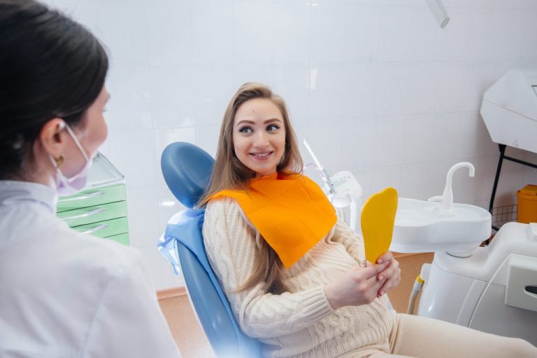 A professional dentist treats and examines the oral cavity of a pregnant girl in a modern dental office. Dentistry