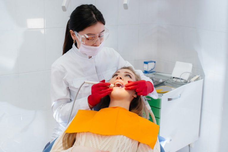 A professional dentist performs treatment and examination of the patient's oral cavity in close-up. Dentistry